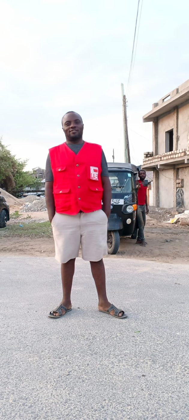 Mose standing in front of his tuk tuk on a Watamu street