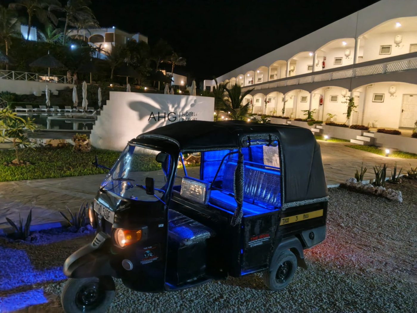 Mose's black tuk tuk parked at an AHG hotel and resort in Watamu at night